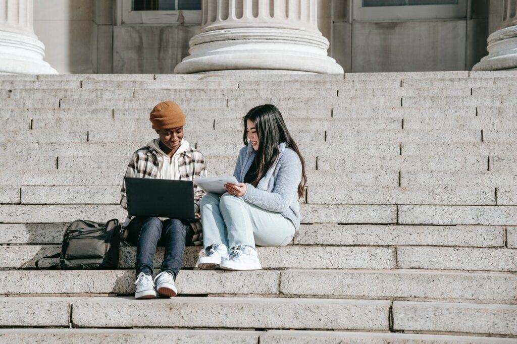 Students sitting on steps. Students are eligible for Windows citizenship licenses