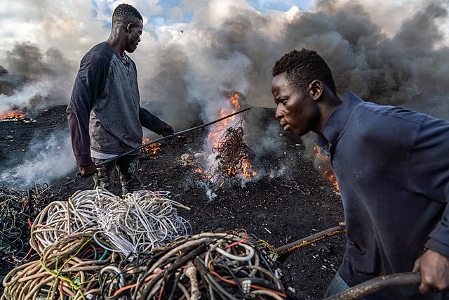 Image of two men burning e-waste in Agbogbloshie, Ghana
